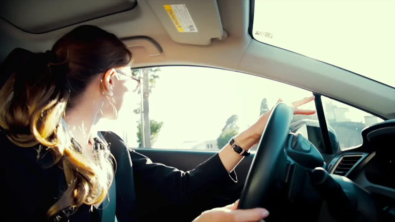 Business woman driving while talking on the phone smiling and laughing