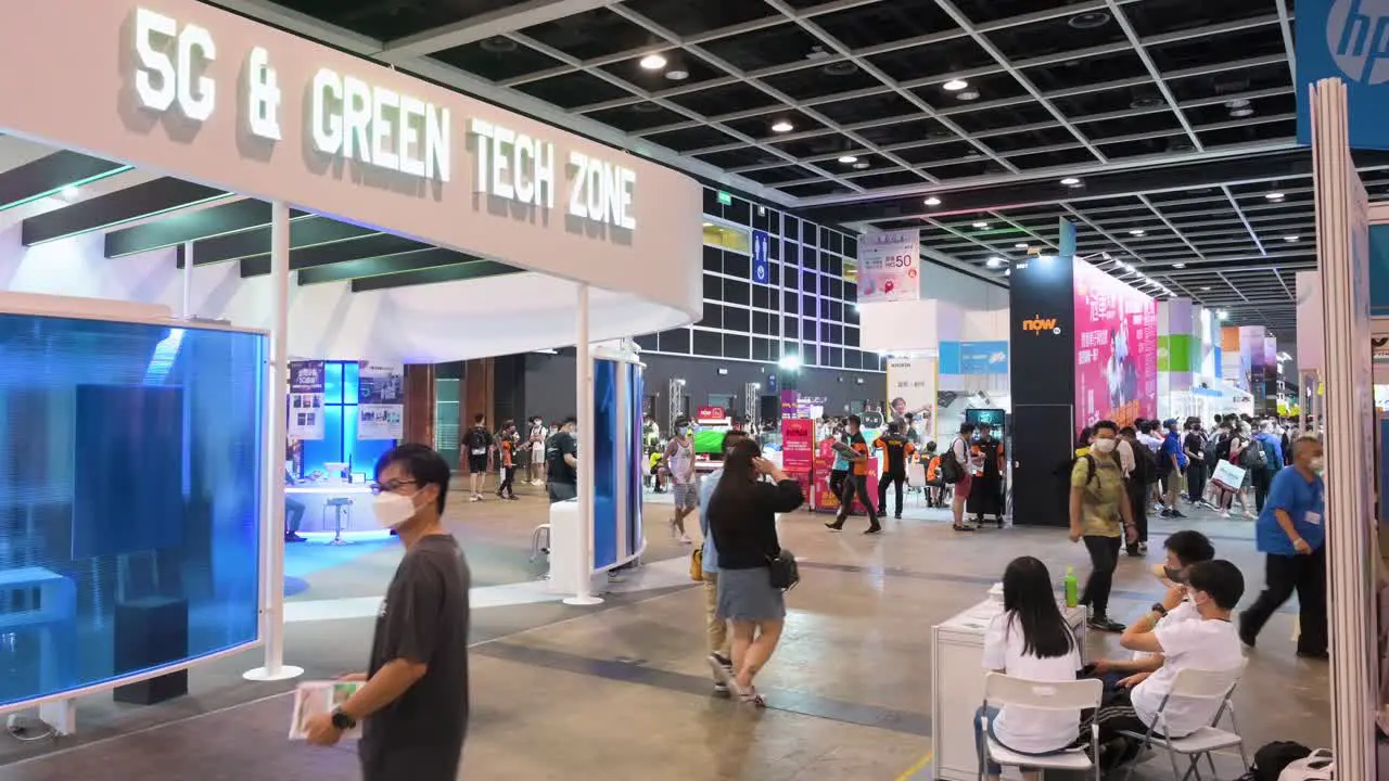 Visitors and customers walk through a technology booth promoting 5G high-speed internet network and 'Green Tech zone' hall during the Hong Kong Computer and Communications Festival event in Hong Kong