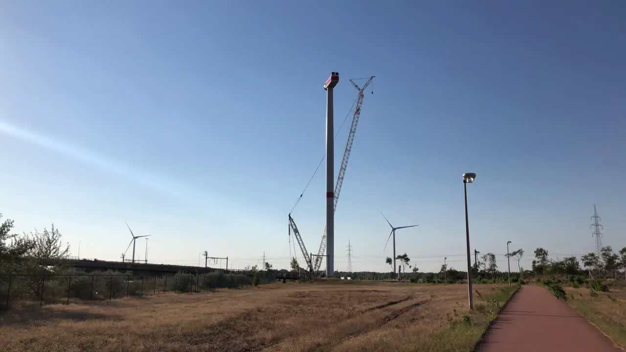 A wind turbine is being set up by a crane in Lommel Belgium