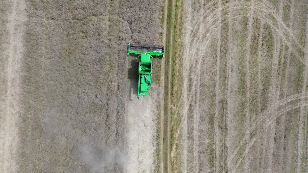 A view of efficient combined harvesting in action when the camera from the drone captures the harvester from above and zooms away at the same time