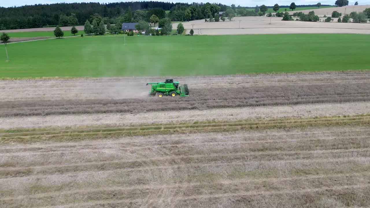 A view of efficient combined harvesting in action when the camera from the drone captures the harvester and rotates around it