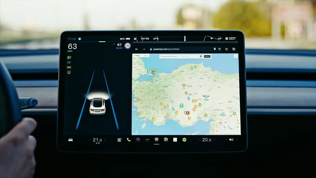 Close-up of Tesla car sensor touchscreen monitor with different apps functions and capabilities autonomous navigating system controlling road traffic speed and battery