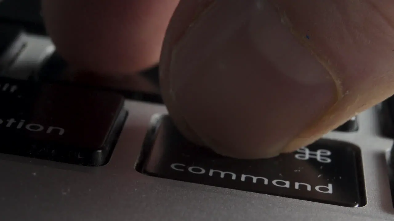 Close-up of Finger Pressing "Command-Z" Key Combination on Laptop Keyboard