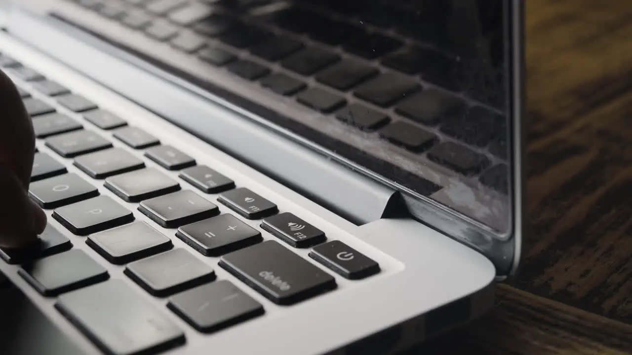 Corner of Laptop Keyboard with Fingers Typing Partially Visible