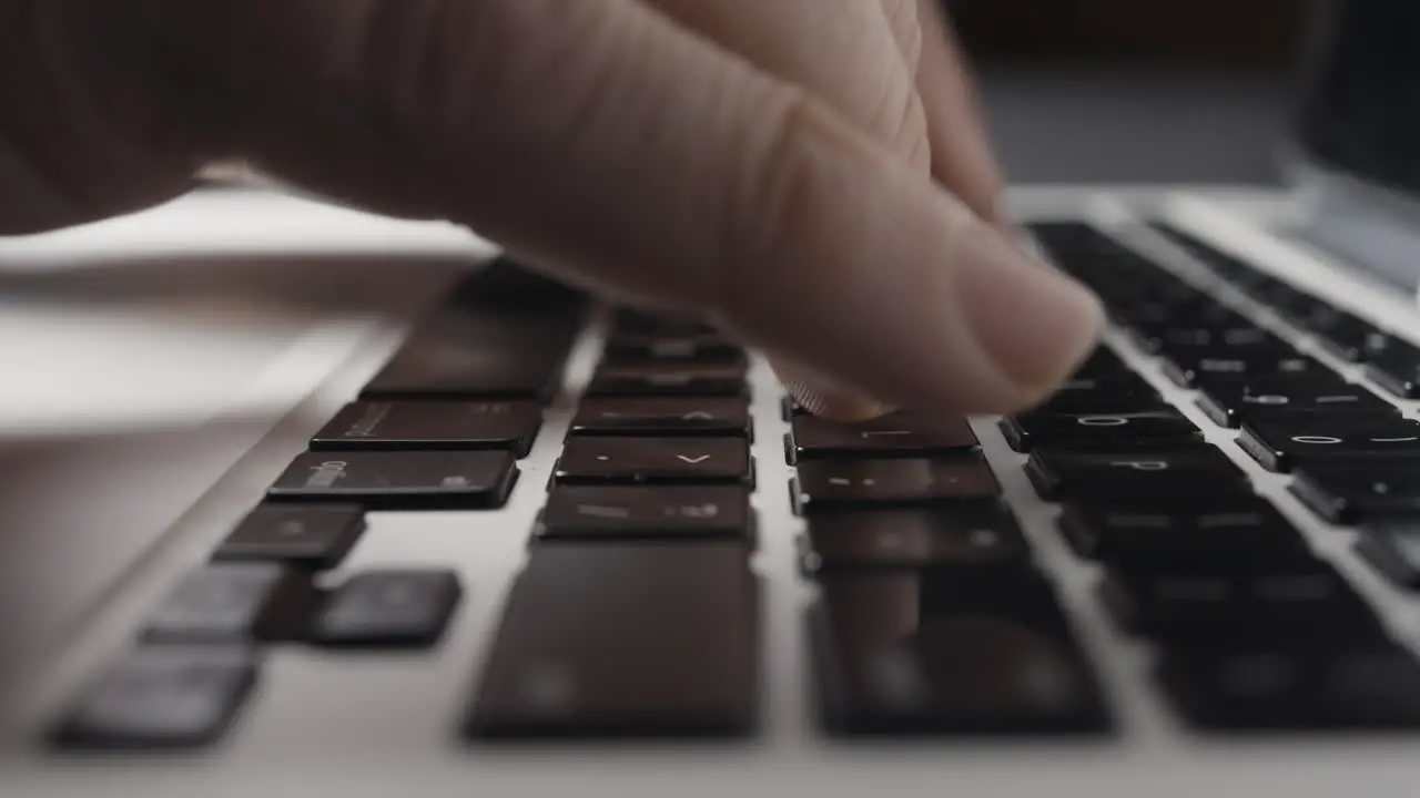 Low-angle Close-up of Caucasian Fingers Typing on Laptop Keyboard