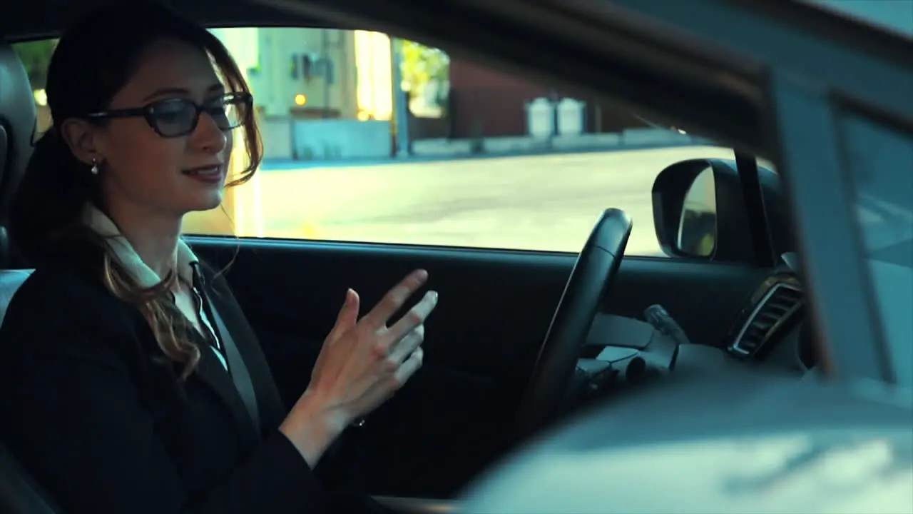 Attractive caucasian business woman in a parked car while talking on the phone