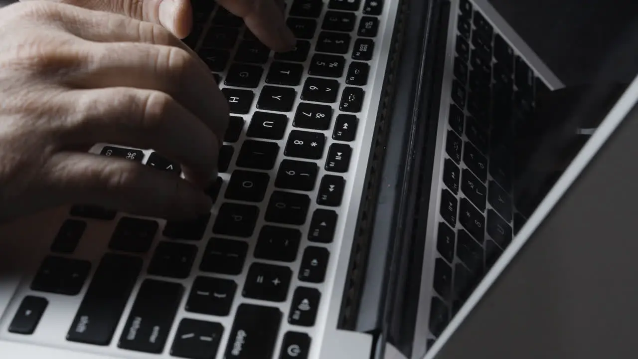 Caucasian Fingers Typing on Laptop Keyboard with Reflection in Screen