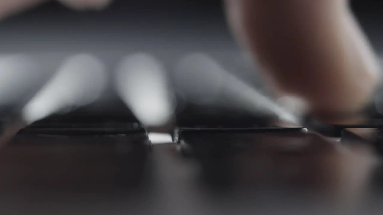 Extreme Close-up of Finger Pressing Keys on Laptop Keyboard