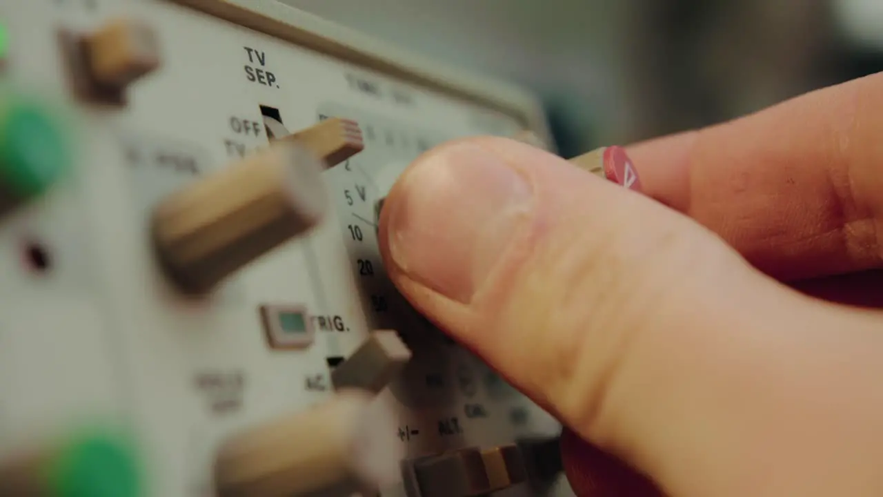 Closeup of finger operating a switch a knob and manipulating a highly sophisticated electronic vintage device