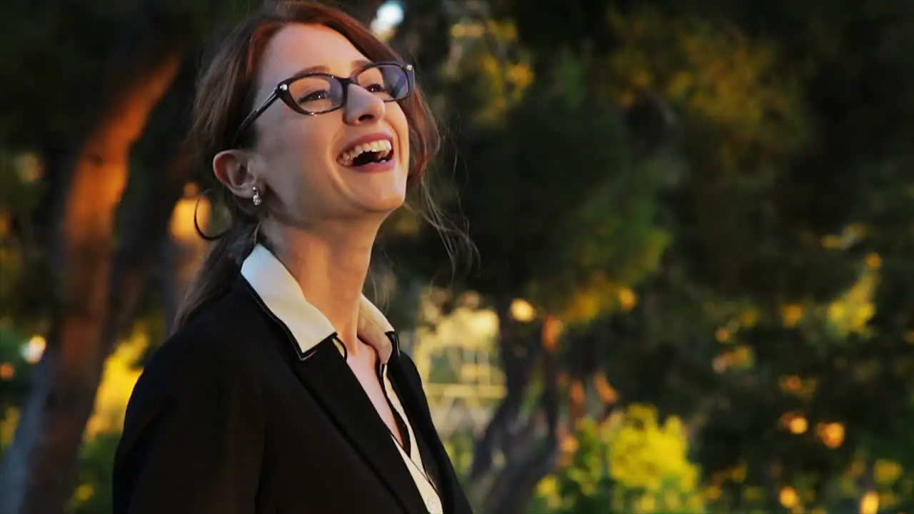 Attractive caucasian business woman looks off camera with an expression of pride and confidence while smiling and laughing