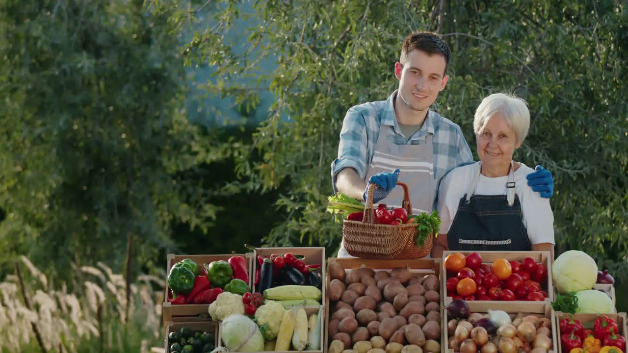 Portrait of an elderly woman with her grandson selling vegetables at a farmers market