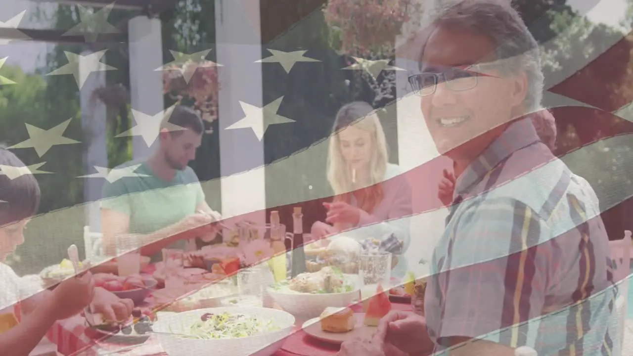 Animation of american flag over happy caucasian family having dinner and smiling