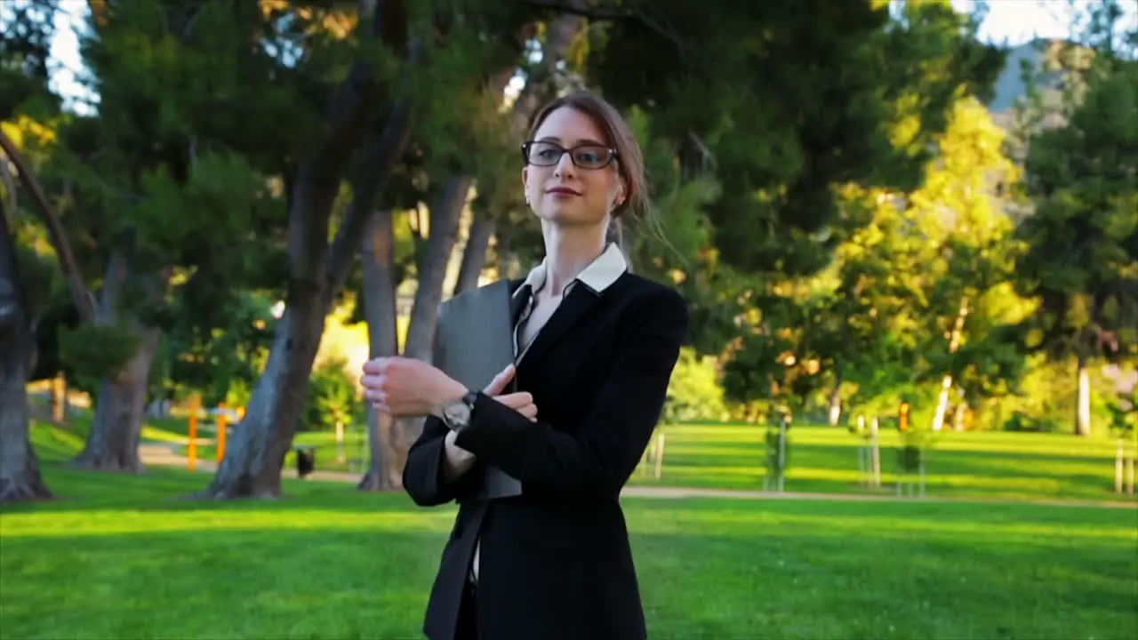 Attractive caucasian business woman walks toward the camera and looks at the camera with an expression of pride and confidence