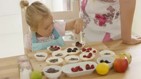 Child and woman preparing muffins on table