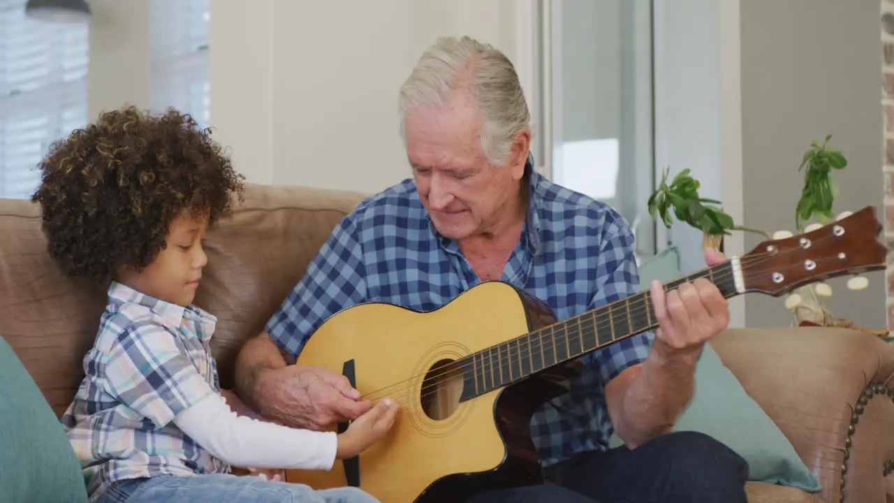 Video of biracial grandson and caucasian grandfather playing the guitar together