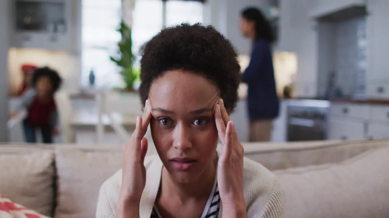 Mixed race woman sitting on couch and looking annoyed