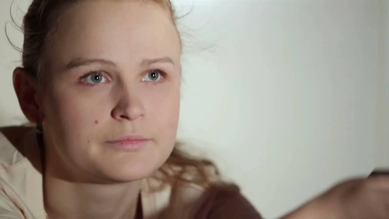 Young woman is watching an interesting film on tv