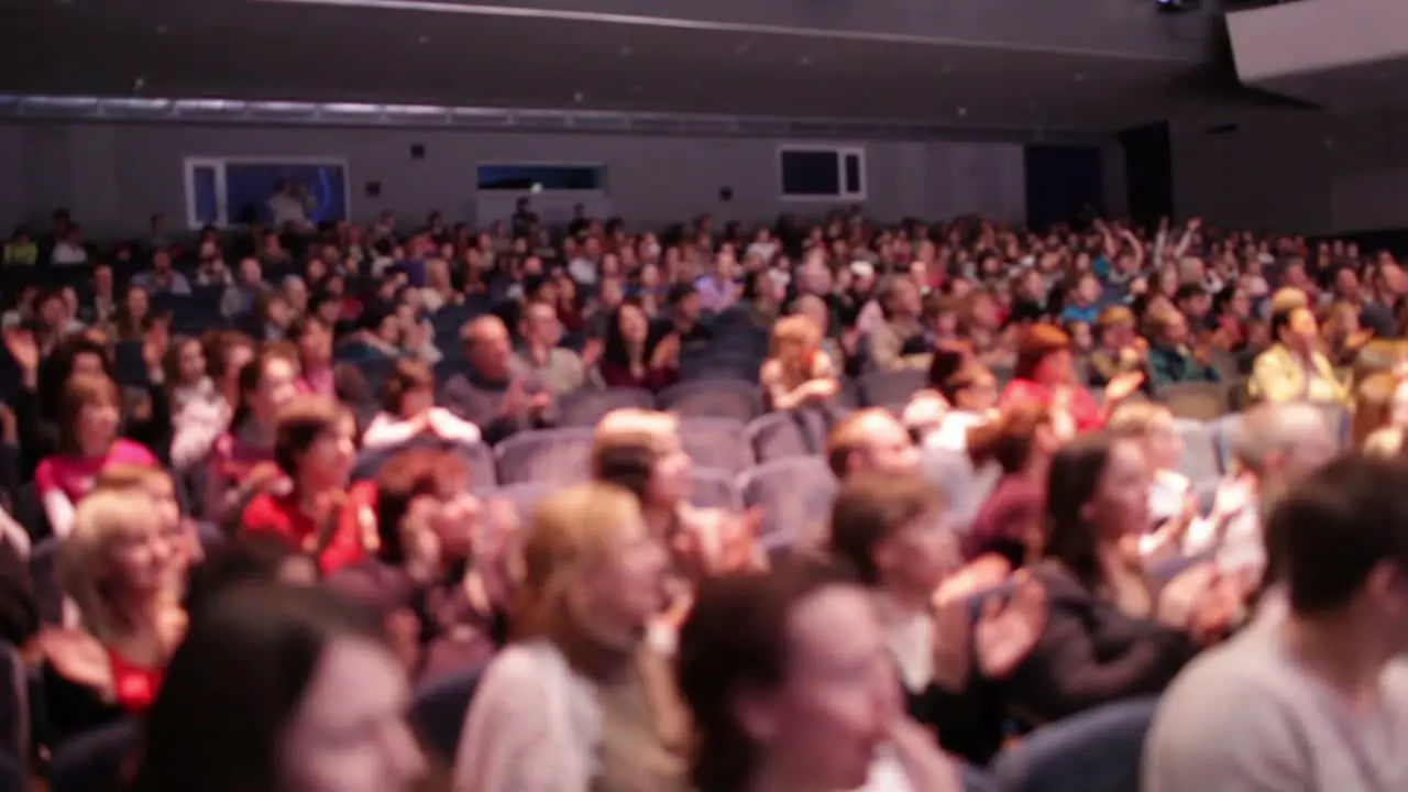 Defocused people applaud after the premiere