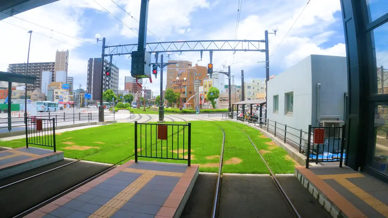 POV shot of tram on tracks moving through Kagoshima city Japan