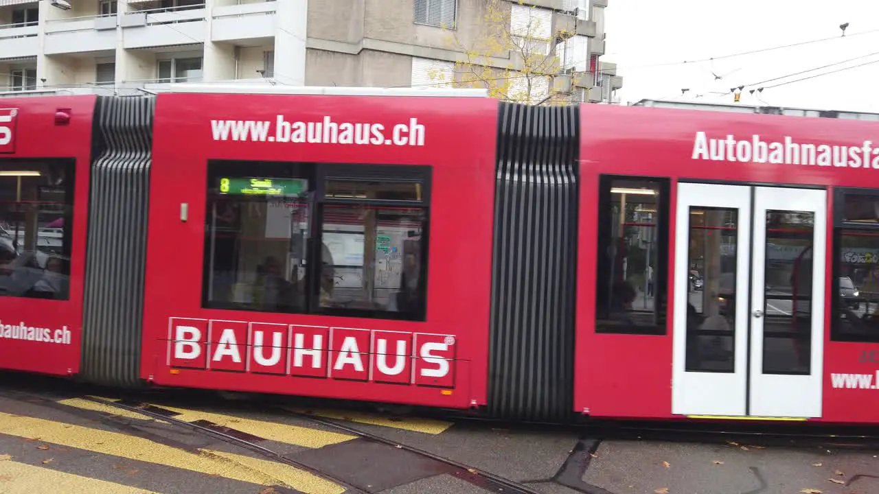 A red tram car travels through the streets of Bern Switzerland in autumn