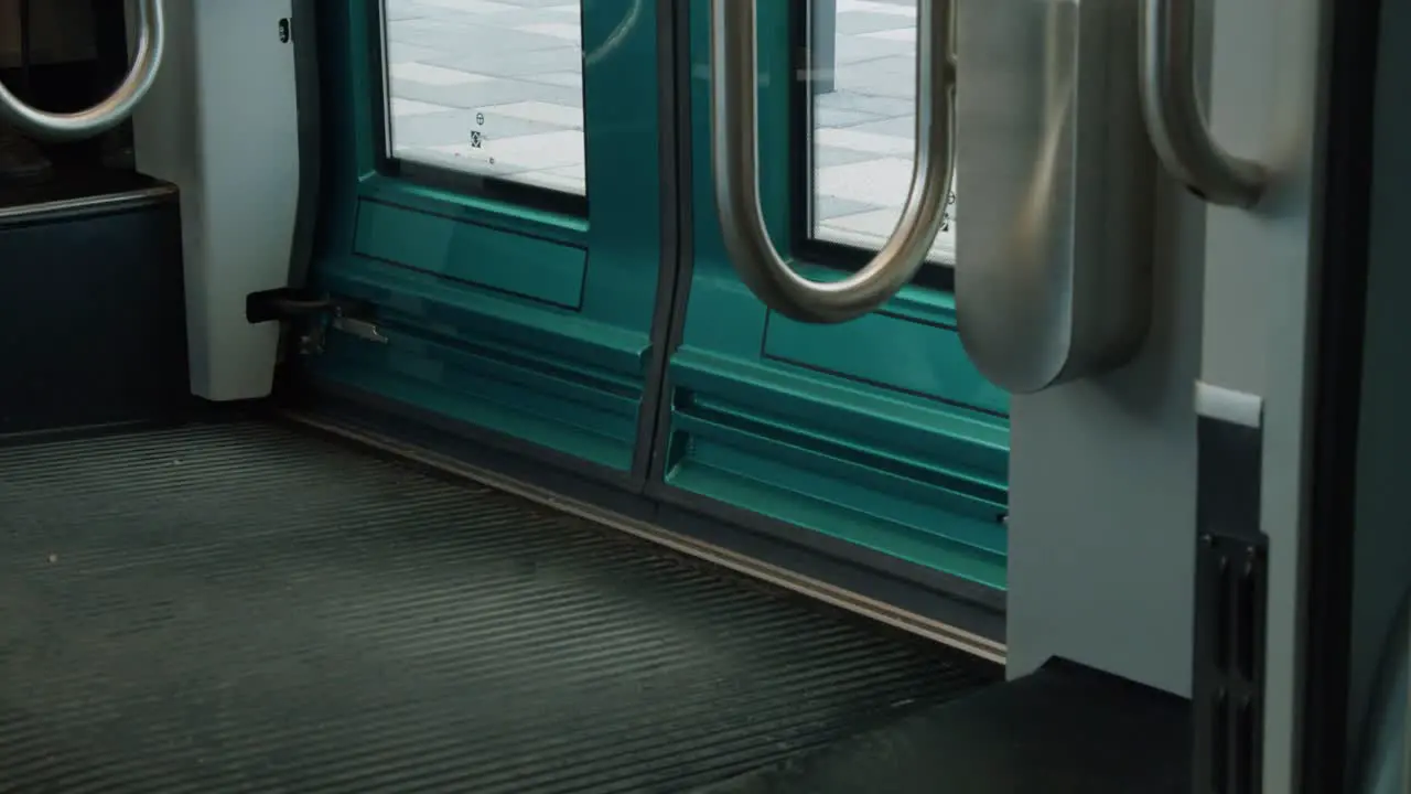 Shiny teal doors close on modern urban public transit commuter train