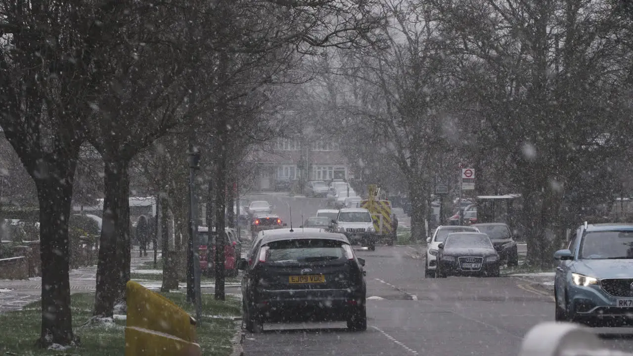 Cars Driving Past On Residential Road In Snow In London