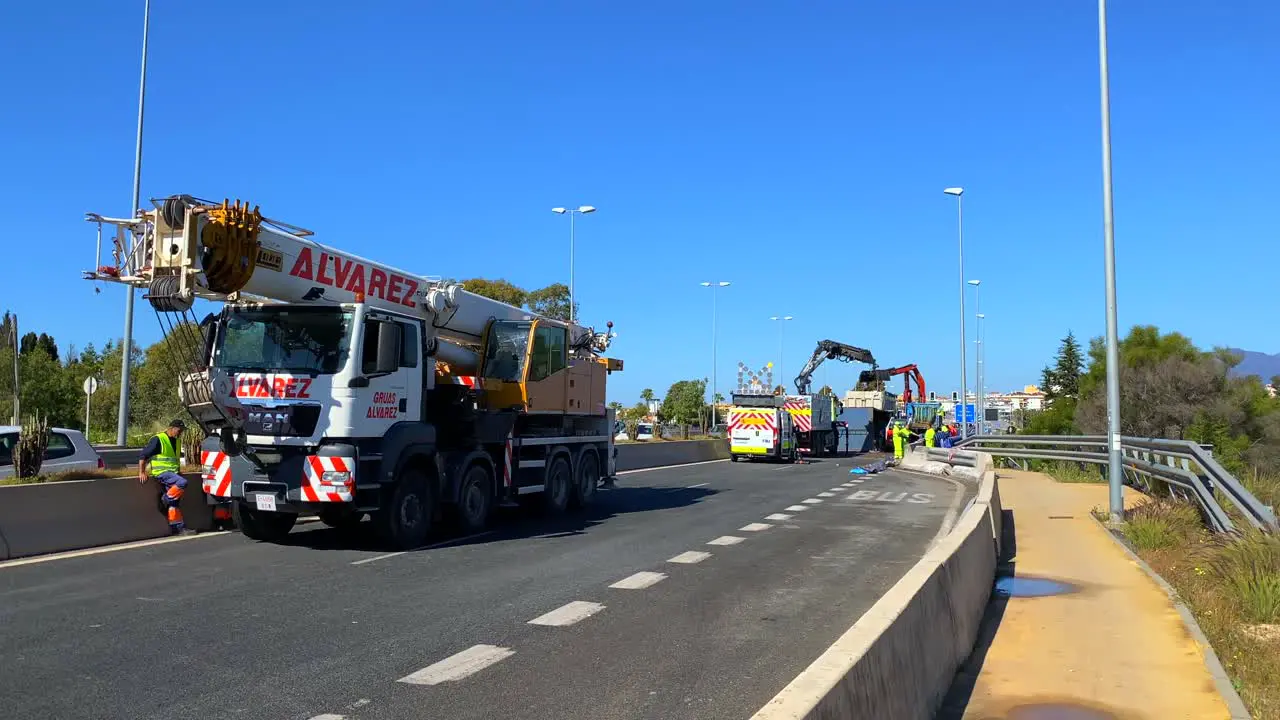 Big truck crash on a highway being cleared up by emergency response vehicles on the main road in Marbella Malaga Spain dangerous transport accident good footage for news story 4K static shot