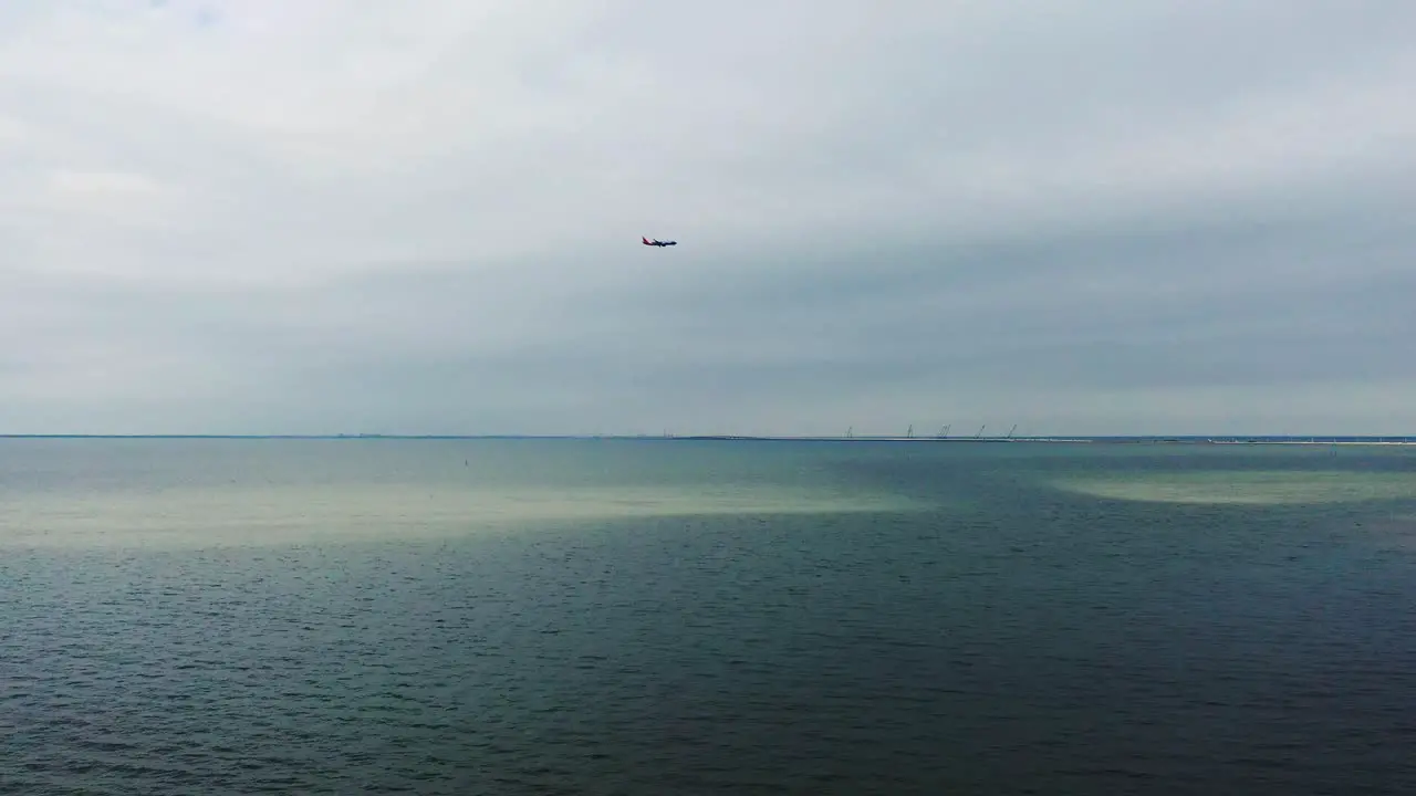 Commercial airliner plane approaching airport landing over Tampa Bay panning