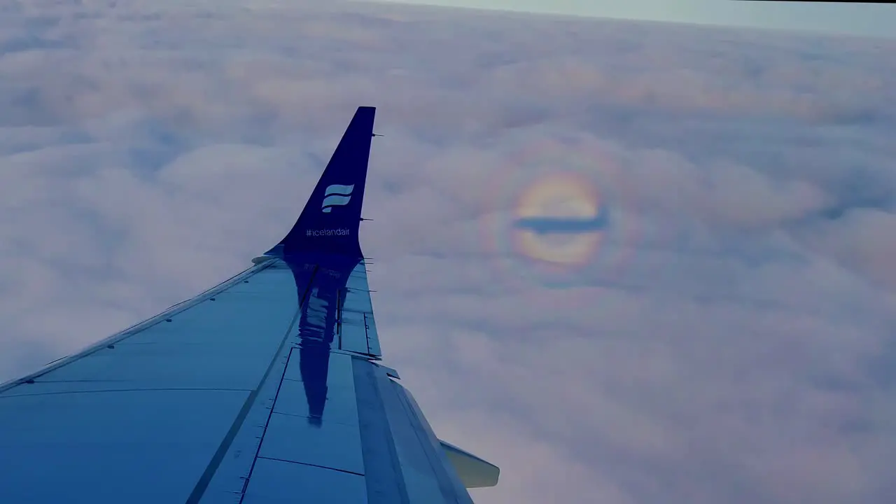 An Iceland Air plane 36 000 feet above the ground at 400 knots with another plane reflection in the window passing