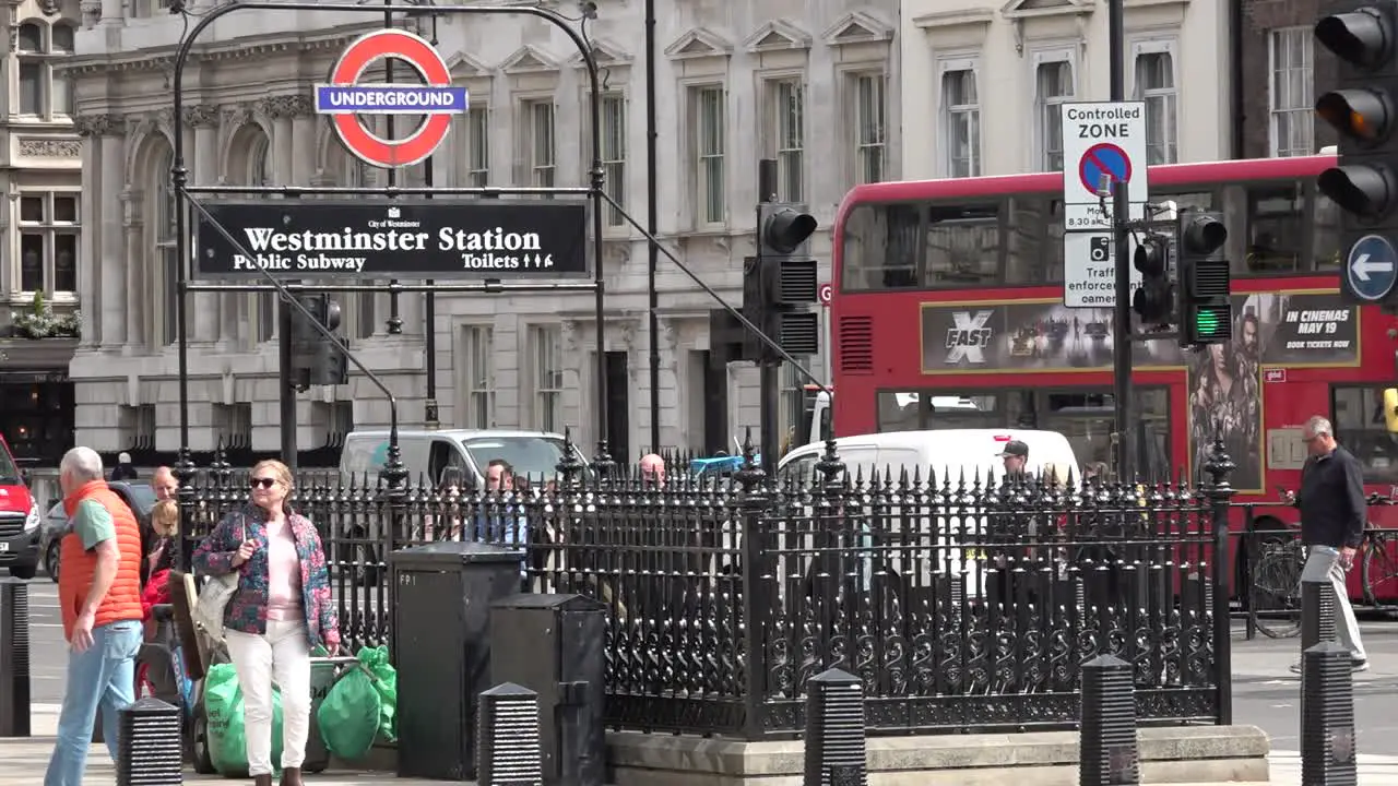 People walk past Westminster Underground entrance along Whitehall in London UK