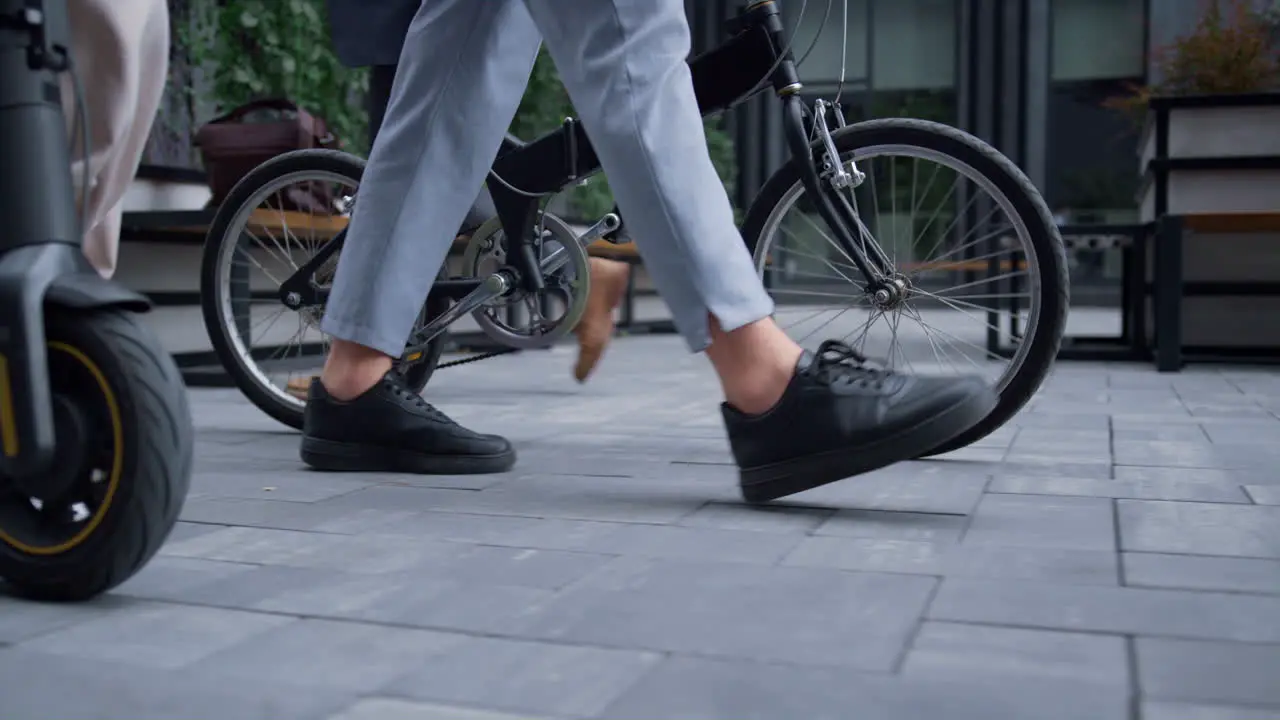 Closeup managers legs walking with bicycle electric scooter at downtown area