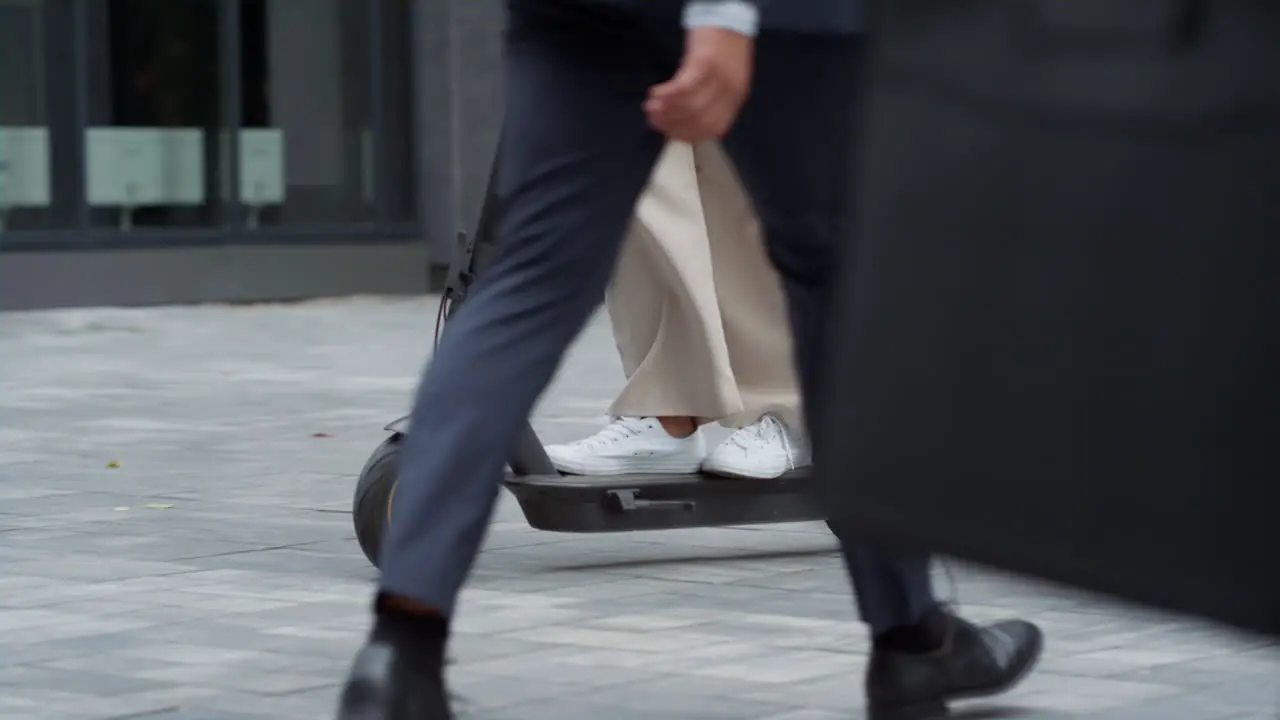 Woman legs riding electric scooter downtown street Alternative transportation