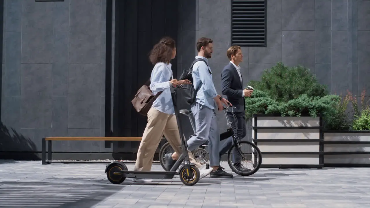 Two colleagues going downtown street talking Shared eco-friendly transportation