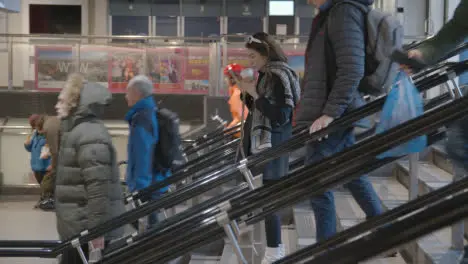 Female Commuter On Stairs Looking At Mobile Phone At London Liverpool Street UK Rail Station