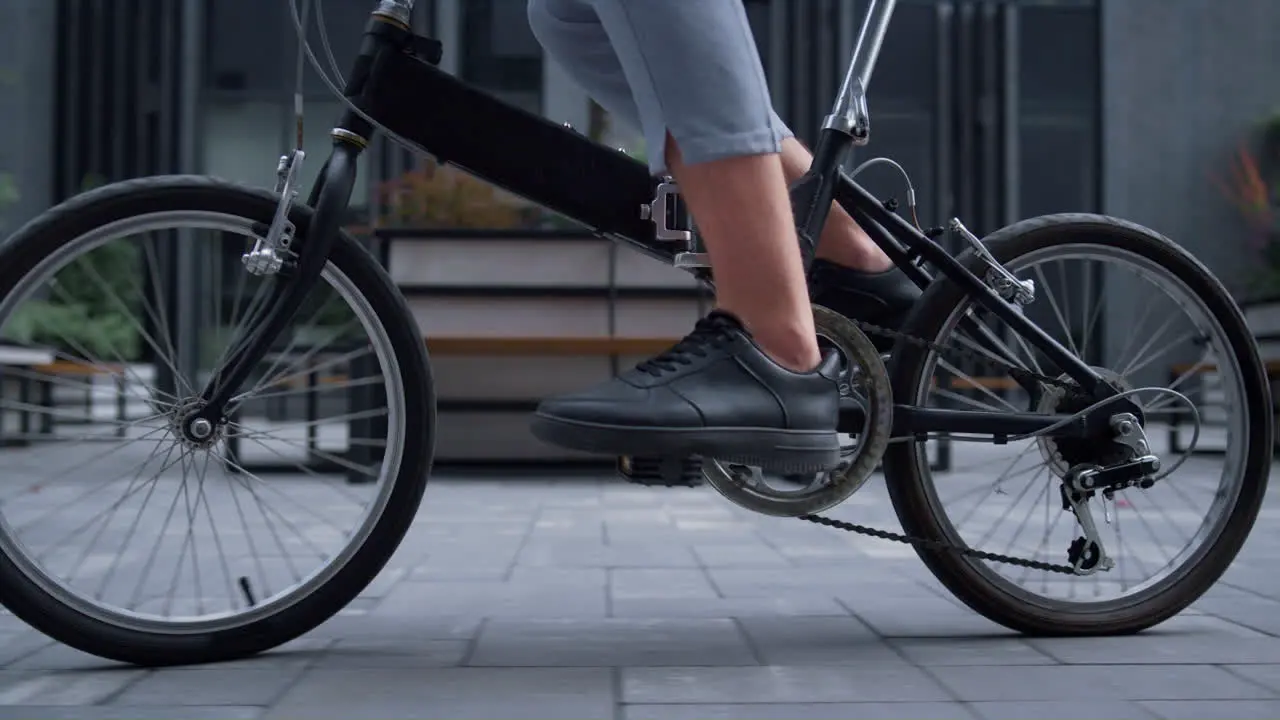 Closeup worker legs pedaling at downtown district Eco-friendly transportation