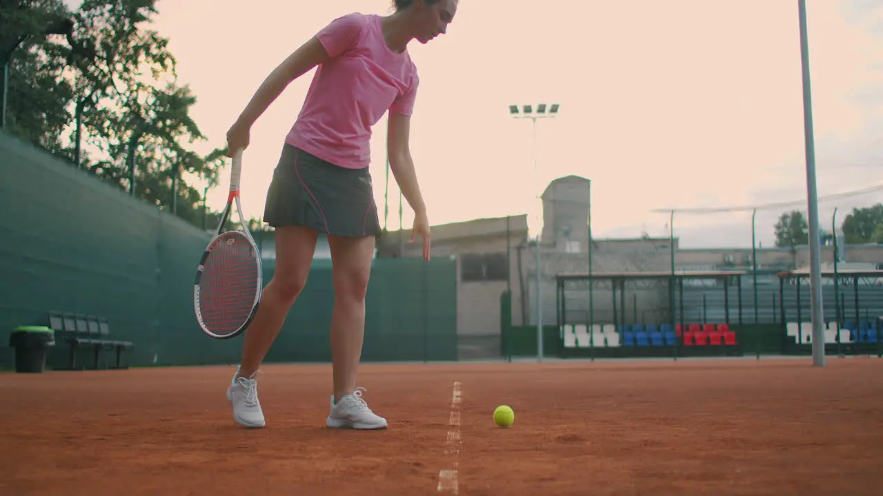 Slow motion female sportsman during her practice A close-up of a girl athlete serves the tennis ball Young woman is hitting the ball with her tennis racket at sunset