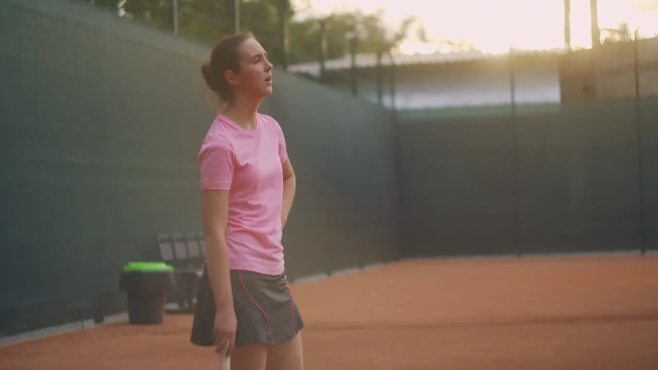 Concentration before the last decisive serve A woman on a tennis court in slow motion and sunlight