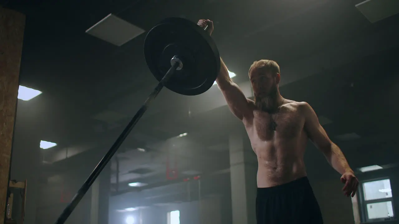 Man doing Single-arm Landmine Squat-to-Press exercise Man doing barbell exercise in the gym Strong man does landmine exercises workout with barbell