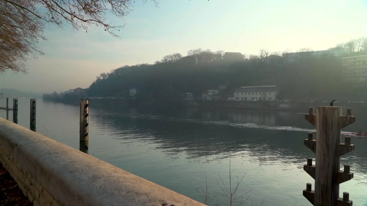 Wide shot of rowers passing by Great Cormorant in Lyon France