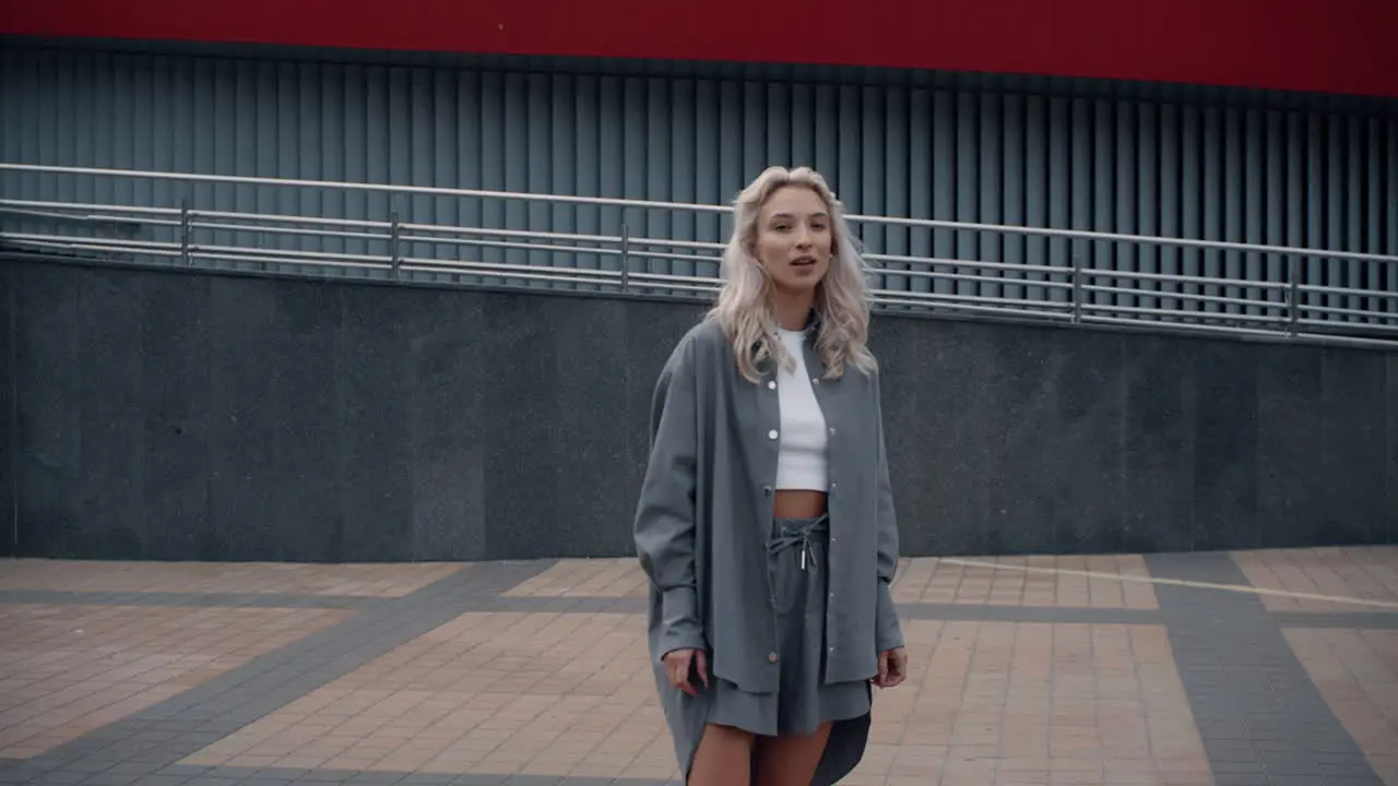 Female model standing alone in city showing gesture hand in downtown