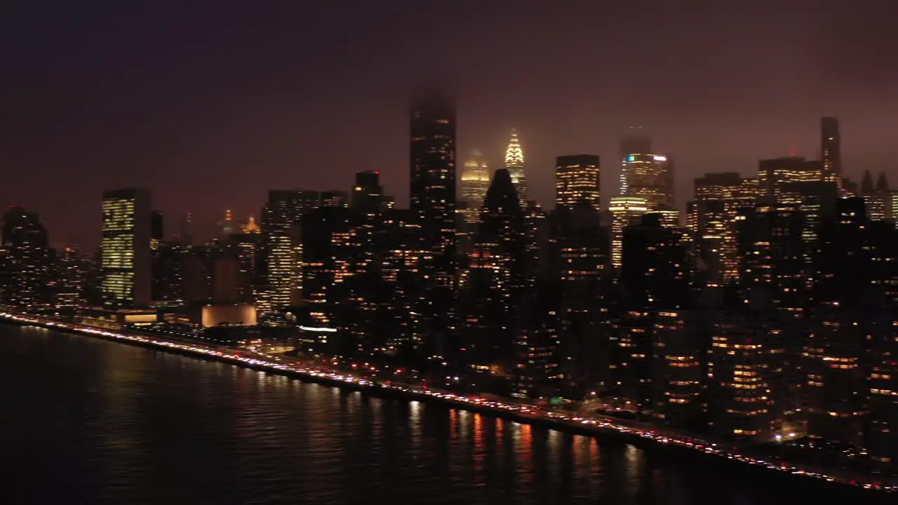 Aerial pan across legendary New York City skyline at foggy twilight