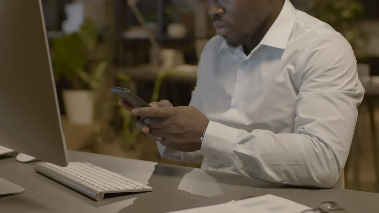 Close Up View Of American Man Texting On Smartphone Sitting At Desk In The Office