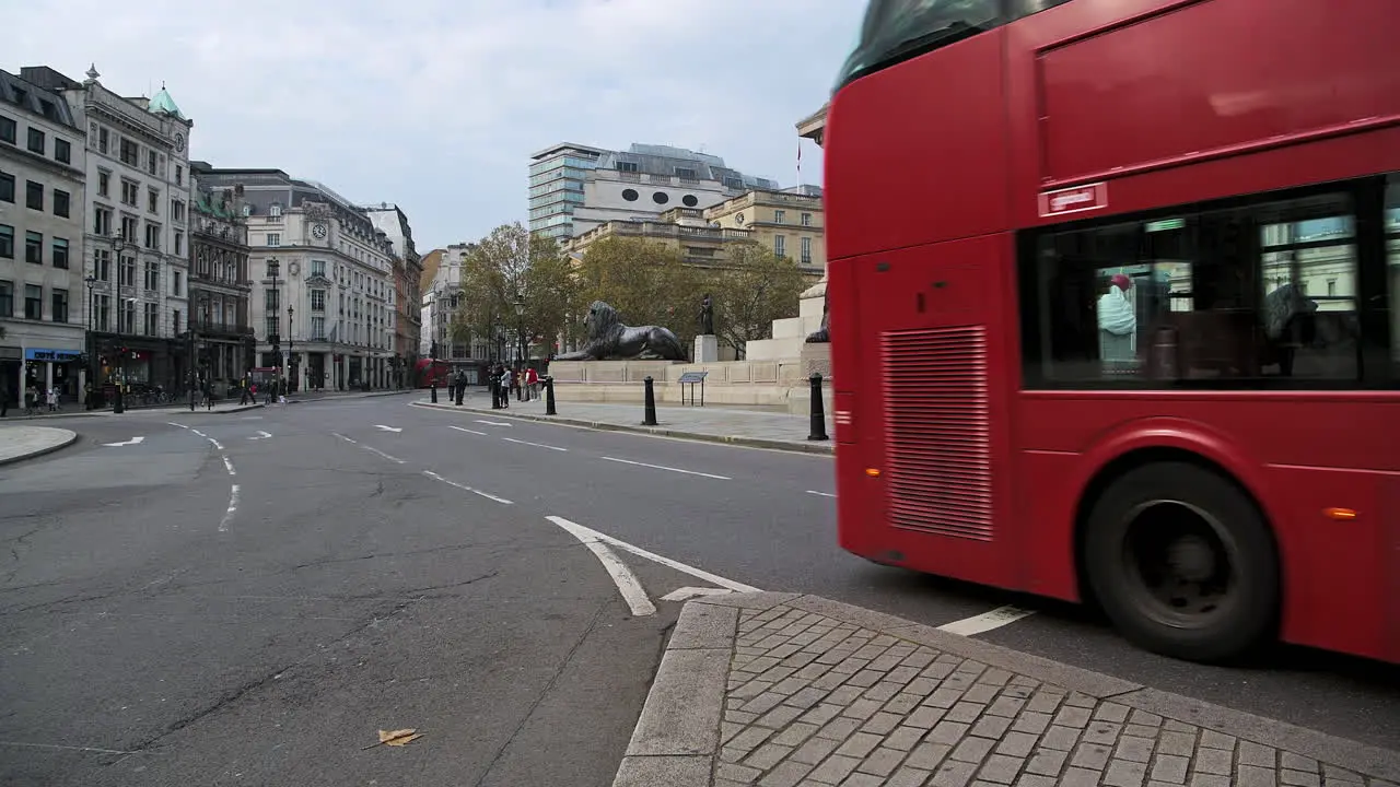 Quiet empty streets in London with only one red London bus in Coronavirus Covid-19 pandemic lockdown at Trafalgar Square and Nelsons Column in London in the City of Westminster England UK