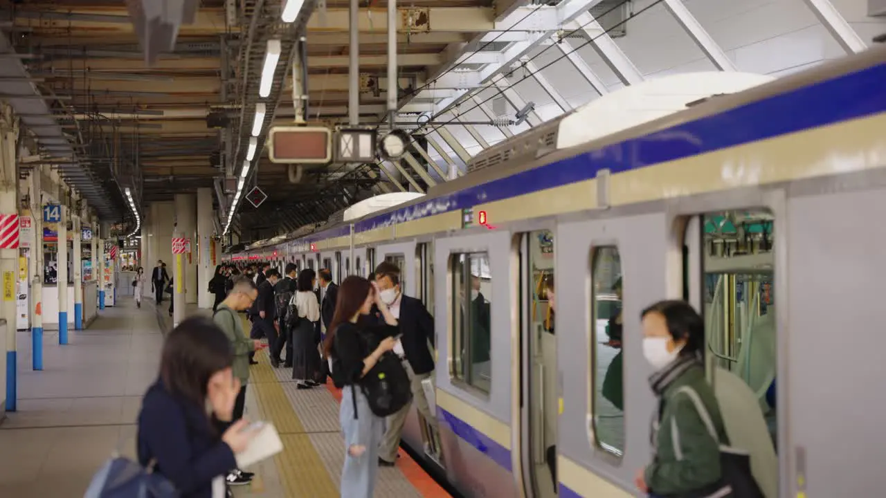 Slow motion shot as train arrives at platform in Yokohama during daytime