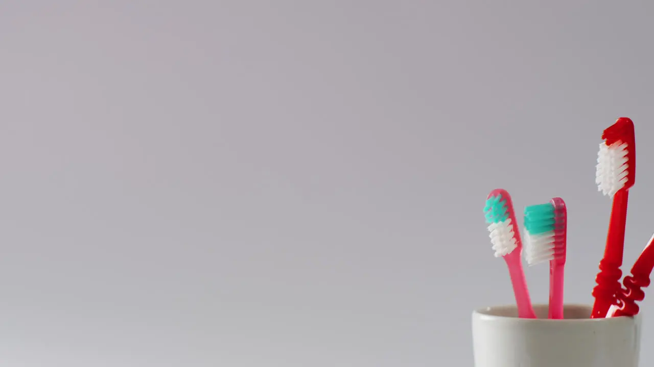 Video of close up of toothbrushes on white background