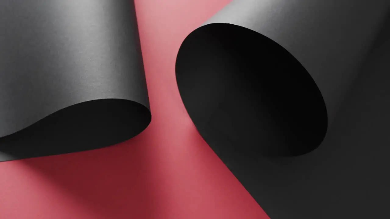 Close up of rolls of black paper and copy space on red background