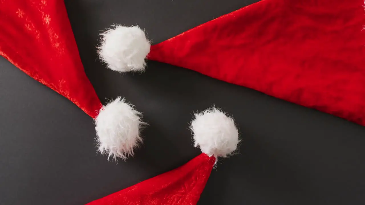 Video of close up of santa hats on gray background