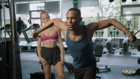 Front view of caucasian female monitor and an athletic african american man in the gym