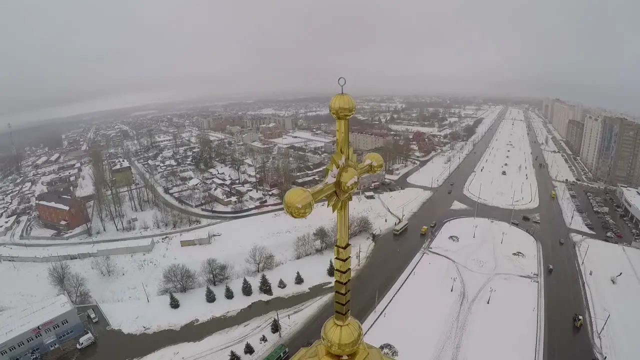 Golden cross on the church in city aerial view