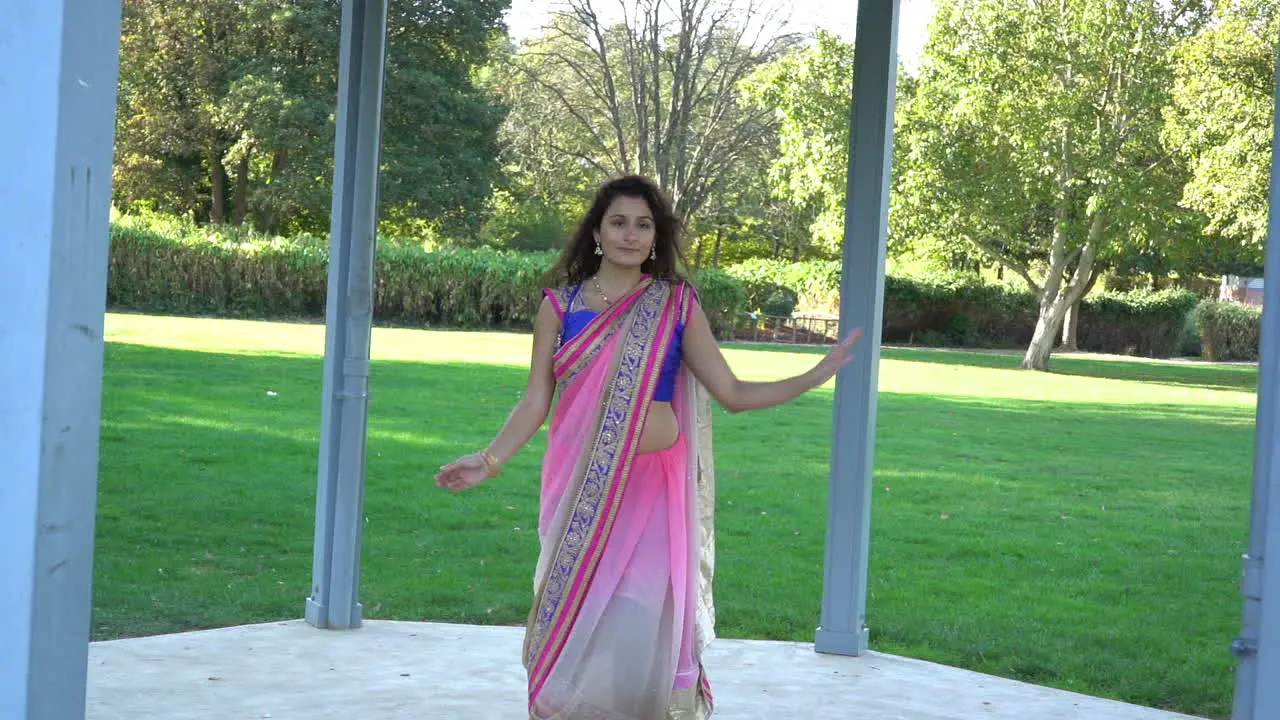 Young beautiful woman wearing traditional indian clothes dancing outdoors